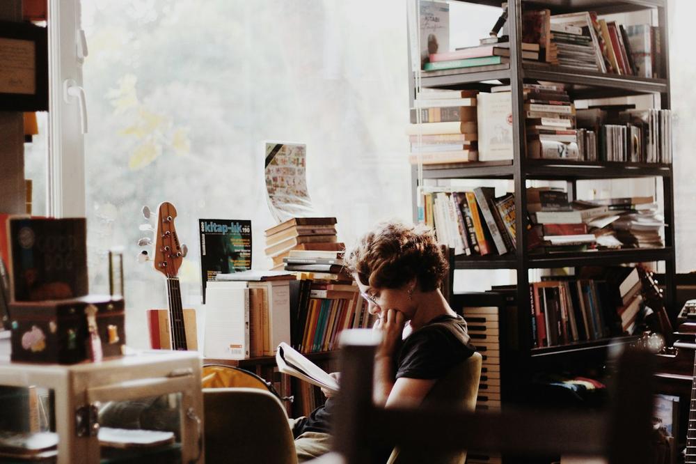 Student reading between bookshelves
